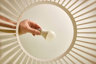 The LED lamp is thrown into the trash for disposal and recycling. View from below. The concept of disposal and processing of waste.