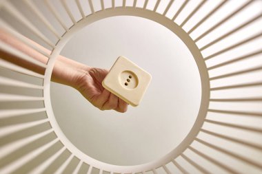 The old broken socket is thrown into the trash for disposal and recycling. View from below. The concept of disposal and processing of waste.
