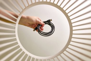 The USB cable is thrown into the trash for disposal and recycling. View from below. The concept of utilization and processing of waste.