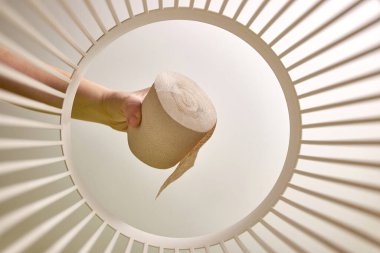 Toilet paper is thrown into the trash for disposal and recycling. View from below. The concept of disposal and processing of waste.