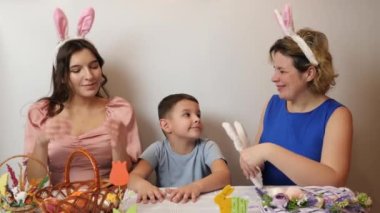 Mother, daughter and son trying on rabbit ears. Celebrating Easter in the family. Easter games and fun.
