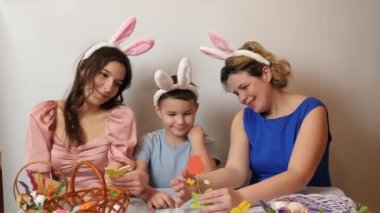 Mother, daughter and son look at festive Easter decorations. Celebrating Easter in the family. Easter games and fun.