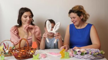 Mother, daughter and son examine rabbit ears. Celebrating Easter in the family. Easter games and fun.