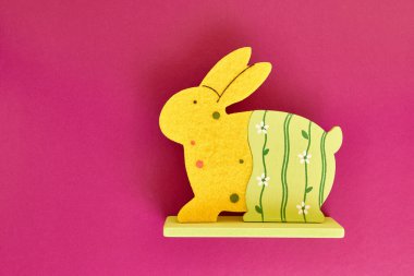 Easter wooden rabbit on a pink background. Easter celebration.