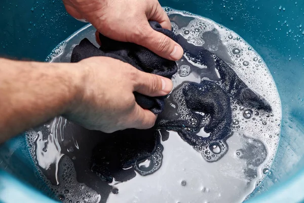 Socks are washed in a large bowl of soapy water.