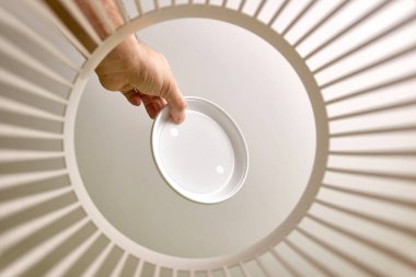 Disposable plastic dishes are thrown into the trash for disposal and recycling. View from below. The concept of disposal and processing of waste.