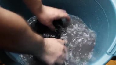 Socks are washed in a large bowl of soapy water. Homework concept.
