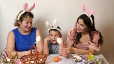 Mother, daughter and son are looking at Easter eggs. Celebrating Easter in the family. Easter games and fun.