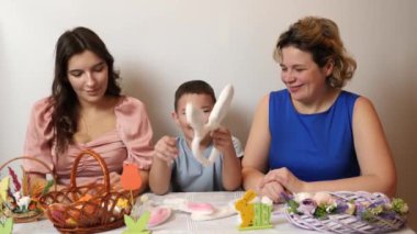Mother, daughter and son trying on rabbit ears. Celebrating Easter in the family. Easter games and fun.