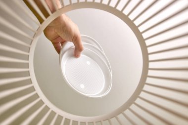 Disposable plastic dishes are thrown into the trash for disposal and recycling. View from below. The concept of disposal and processing of waste.