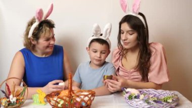 Mother, son and daughter are treated to an Easter chocolate egg. Celebrating Easter in the family. Easter games and fun.