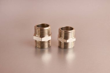 Double nipple with external thread for connecting pipeline elements on a silver background. Plumbing and heating.