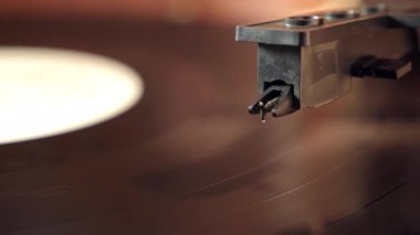 During playback of a music recording, the needle is lowered to the surface of the record. Audio equipment of the past.