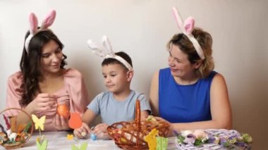 Mother, daughter and son are looking at Easter eggs. Celebrating Easter in the family. Easter games and fun.