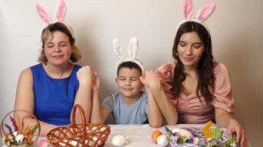 Mother, daughter and son dream, holding hands with closed eyes. Celebrating Easter in the family. Easter games and fun.