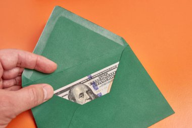 A green envelope with a $100 bill inside.