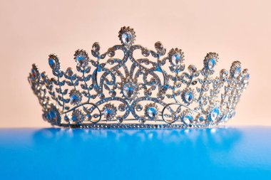 The crown is decorated with stones on a blue stand.