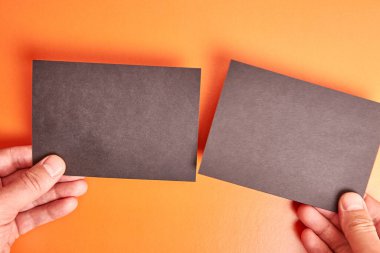 The man holds two black sheets of paper in his hands. Banner for advertising.