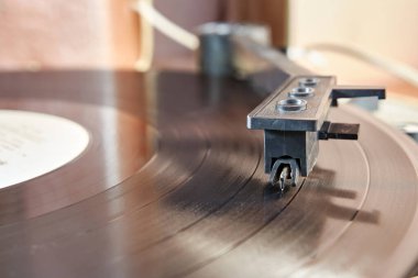 During playback of a music recording, the needle is lowered to the surface of the record. Audio equipment of the past.