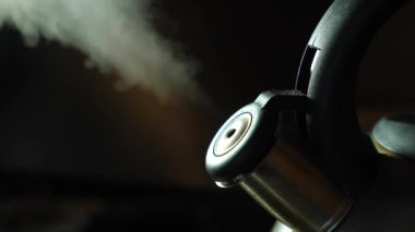 The water in the kettle boils and steam comes out. Making coffee or tea.