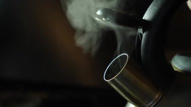 The water in the kettle boils and steam comes out. Making coffee or tea.