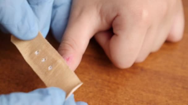 Κόλλησε Ένα Μπάλωμα Στο Γρατζουνισμένο Δάχτυλο Του Παιδιού Πρώτες Βοήθειες — Αρχείο Βίντεο