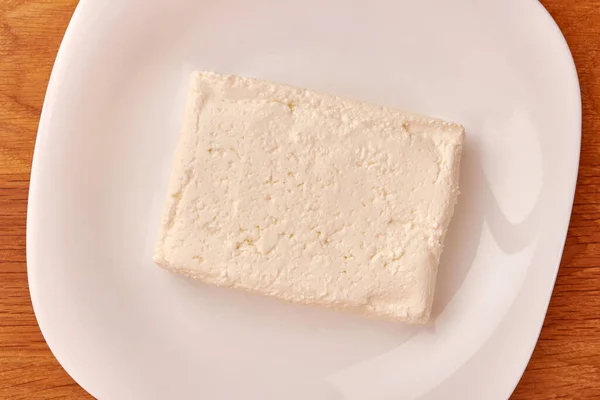 Kawałek Kwaśnego Sera Mleka Białym Talerzu — Zdjęcie stockowe