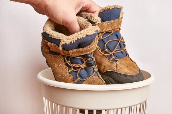 Old shoes are thrown into the trash. Disposal and recycling of old shoes.