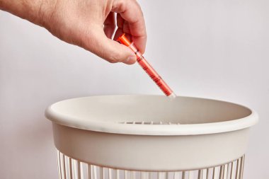Plastik bir sıvı ilaç kutusu çöpe atılır. Plastiğin imha ve geri dönüşümü.