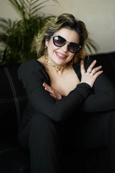 Una Mujer Sonriente Vestido Negro Con Gafas Oscuras Está Sentada — Foto de Stock