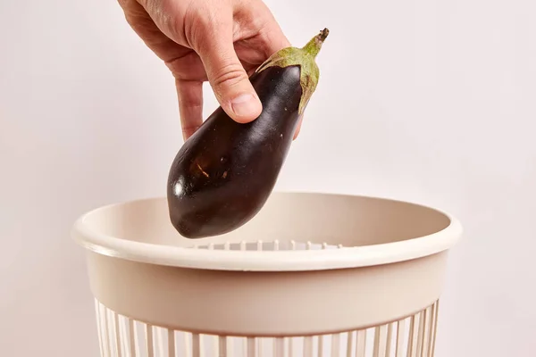 Expired eggplant is thrown into the trash. Disposal and recycling of food products.