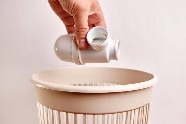 Eski kırık bir plastik kanalizasyon borusu bir çöp kutusuna atılır. Plastik öğütme ve geri dönüşüm.