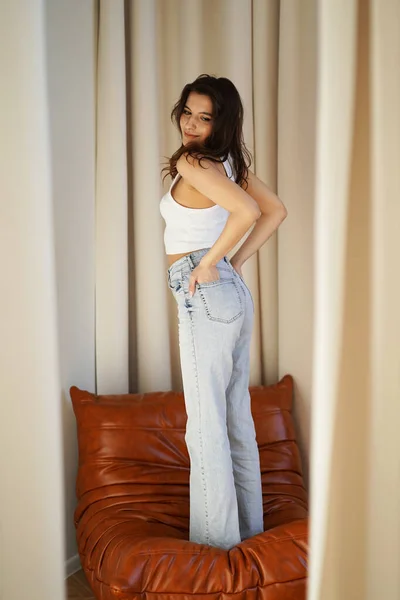 Una Bella Ragazza Jeans Una Shirt Bianca Piedi Sul Divano — Foto Stock