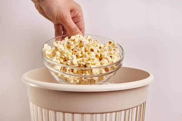 Expired popcorn is thrown into the trash can. Disposal and recycling of food products.