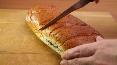 Lezzetli haşhaşlı kek tahta bir tahtanın üzerinde parçalara ayrılır..