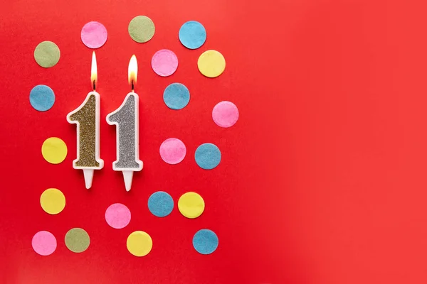 stock image Number 11 on a red background with colored confetti. Happy birthday candles. The concept of celebrating a birthday, anniversary, important date, holiday. Copy space. banner