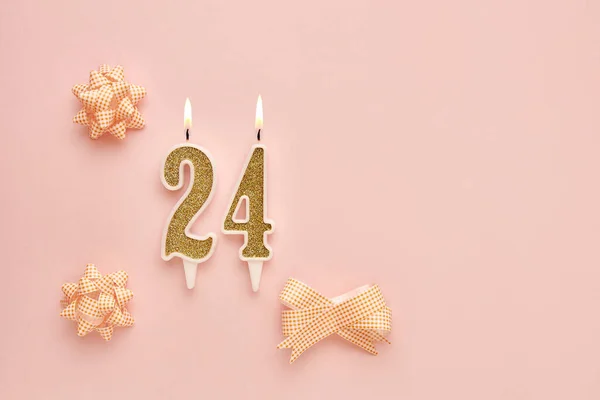 Number 24 on a pastel pink background with festive decorations. Happy birthday candles. The concept of celebrating a birthday, anniversary, important date, holiday. Copy space. banner