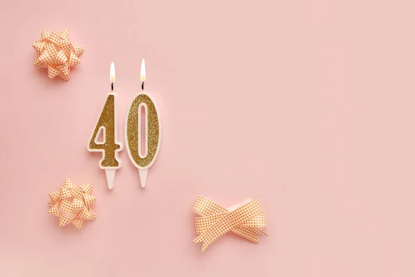 Number 40 on a pastel pink background with festive decorations. Happy birthday candles. The concept of celebrating a birthday, anniversary, important date, holiday. Copy space. banner