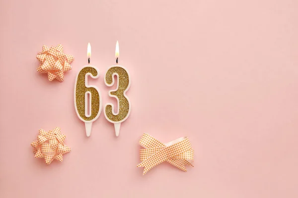 お祝いの装飾が施されたパステルピンクの背景に番号63を持つキャンドル お誕生日おめでとうございます 誕生日 記念日 重要な日付 休日を祝うという概念 コピースペース — ストック写真