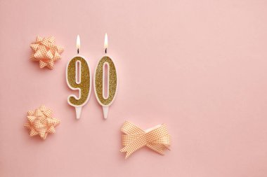 90 numaralı mumlar, rengarenk dekorlu, pastel pembe arka planda. Mutlu doğum günü mumları. Doğum günü, yıldönümü, önemli randevu, tatil kavramı. Uzayı kopyala Pankart