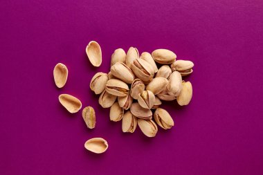 Pembe arka planda kabuklu fıstık yığını..
