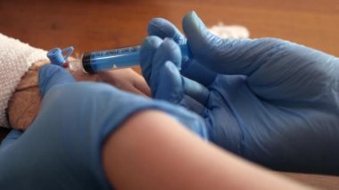 Doktor kolundaki kateterden çocuğa ilaç enjekte etmek için pompa kullanıyor..