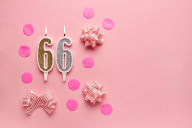 Pastel pembe arka planda 66 numara, şenlikli dekorlu. Mutlu doğum günü mumları. Doğum günü, yıldönümü, önemli randevu, tatil kavramı. Uzayı kopyala Pankart