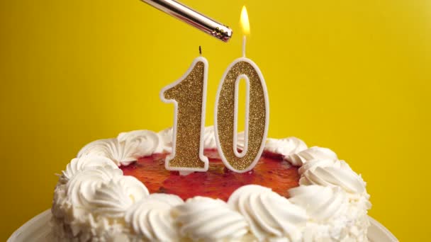 10番の形のキャンドルは 休日のケーキに挿入され 点灯されます 誕生日やランドマークイベントを祝う お祝いのクライマックス — ストック動画