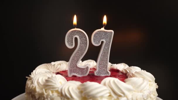 休日のケーキに挿入された番号27の形でキャンドルが吹き飛ばされます 誕生日やランドマークイベントを祝う お祝いのクライマックス — ストック動画
