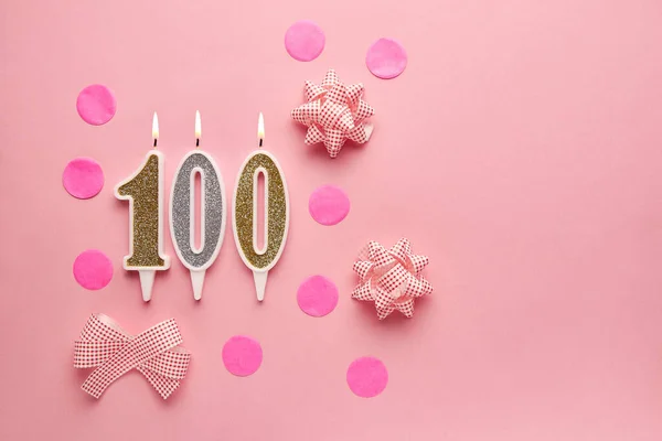 Number 100 on pastel pink background with festive decor. Happy birthday candles. The concept of celebrating a birthday, anniversary, important date, holiday. Copy space. banner