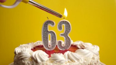 Bayram pastasına eklenmiş 63 numaralı mum şeklinde bir mum yakılıyor. Bir doğum gününü ya da tarihi bir olayı kutluyoruz. Kutlamanın doruk noktası..
