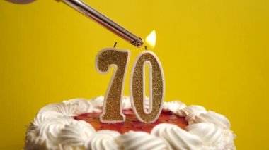 Tatil pastasının içine yerleştirilmiş 70 numara şeklinde bir mum yakılıyor. Bir doğum gününü ya da tarihi bir olayı kutluyoruz. Kutlamanın doruk noktası..