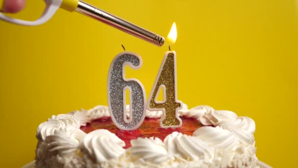 休日のケーキに挿入された番号64の形でキャンドルが点灯します 誕生日やランドマークイベントを祝う お祝いのクライマックス — ストック動画