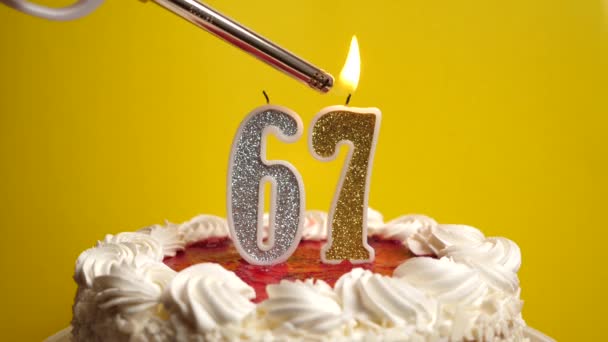 番号67の形でキャンドルは 休日のケーキに挿入され 点灯されます 誕生日やランドマークイベントを祝う お祝いのクライマックス — ストック動画